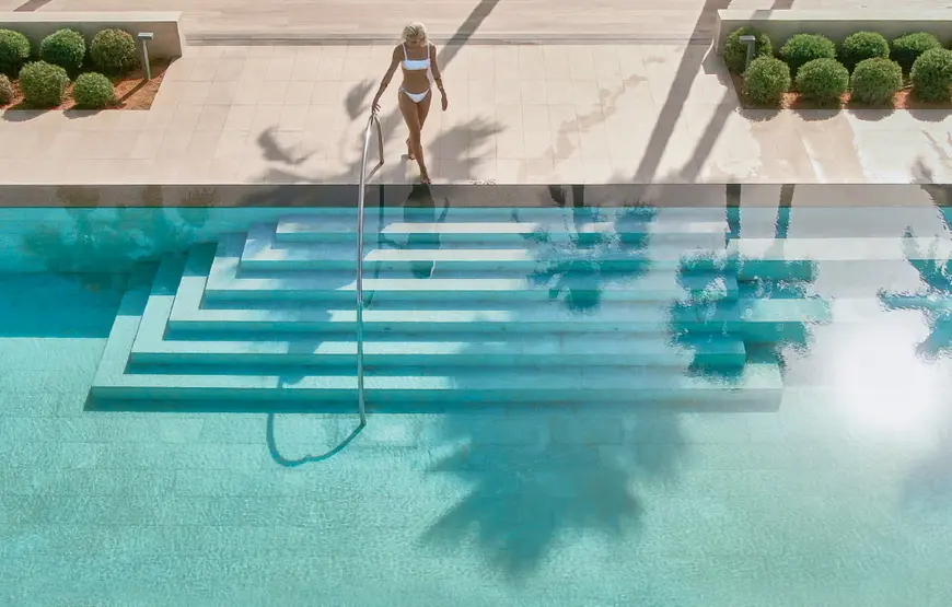 una-donna-vista-dall-alto-scende-i-gradini-di-una-piscina