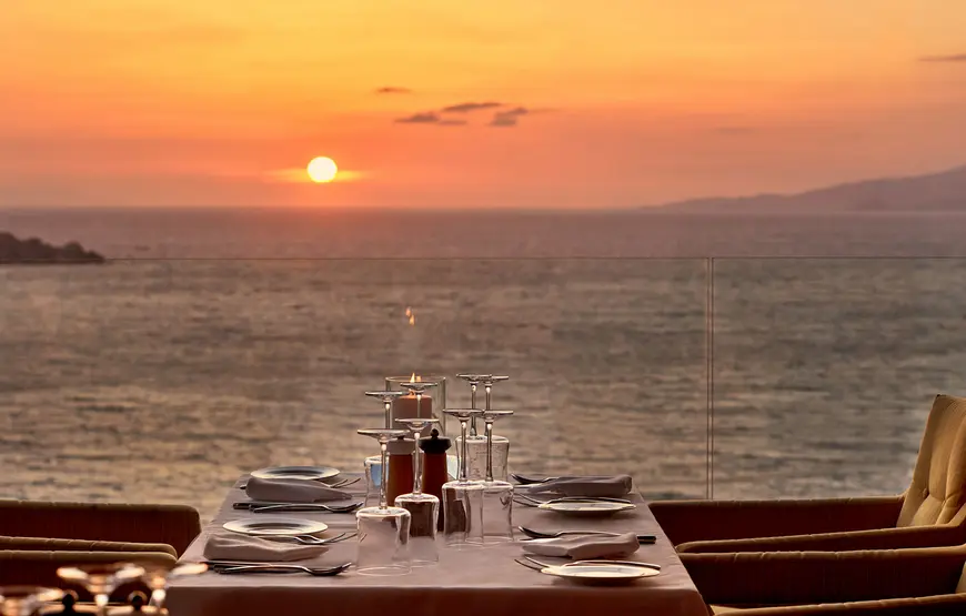 tavolo-apparecchiato-su-una-veranda-vista-mare-con-tramonto