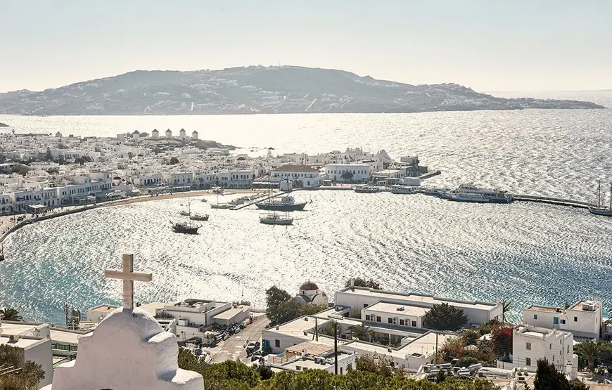 vista-di-mykonos-con-le-barche-in-mezzo-al-mare-e-le-case-bianche-lungo-la-costa