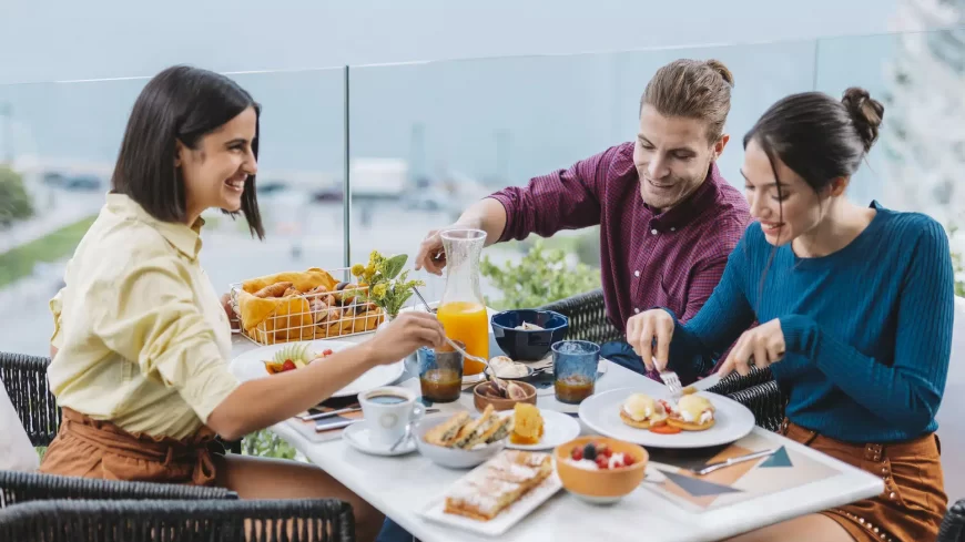 tre-persone-fanno-colazione-sulla-terrazza-del-ristorante-electra-palace-a-salonicco-con-la-classica-colazione-greca