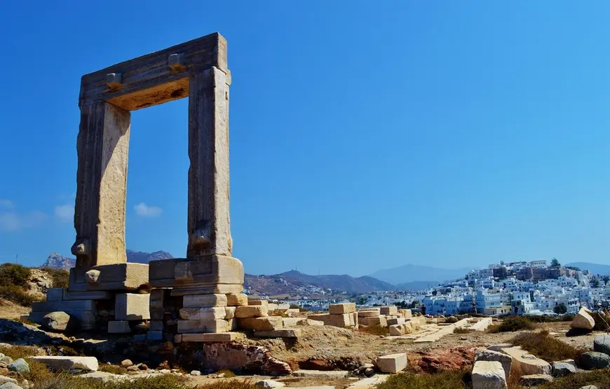 porta-di-marmo-in-mezzo-alle-rovine-di-un-tempio-sullo-sfondo-la-città-di-naxos