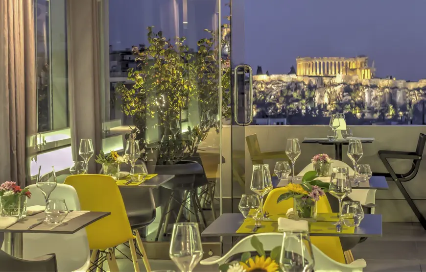 ristorante-sulla-terrazza-del-polis-grand-tovaglie-gialle-vista-acropoli-illuminata-giardino-pensile-di-fianco